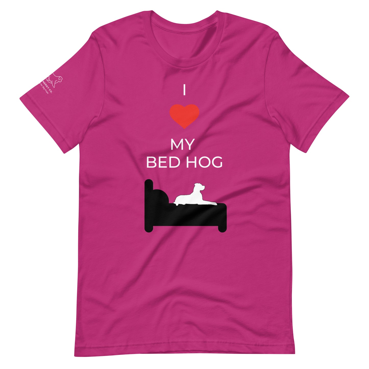 Front of a berry pink t-shirt that reads "I love my bed hog" in white text over an illustration that is the white silhouette of a large dog laying on the dark silhouette of a bed. The word "love" is replaced by a red heart symbol.