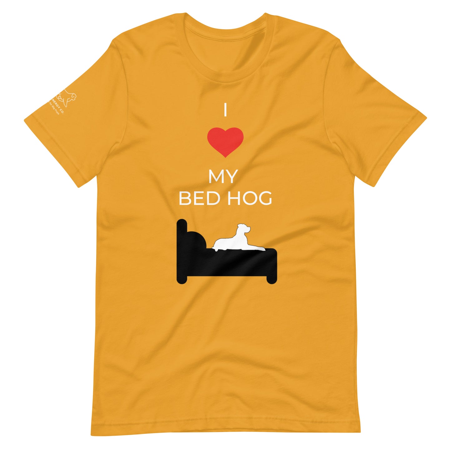 Front of a mustard yellow t-shirt that reads "I love my bed hog" in white text over an illustration that is the white silhouette of a large dog laying on the dark silhouette of a bed. The word "love" is replaced by a red heart symbol.
