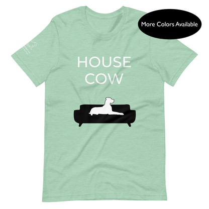 Front of a heather prism mint t-shirt that reads "House Cow" in white text over an illustration that is the white silhouette of a large dog laying on the dark silhouette of a couch.