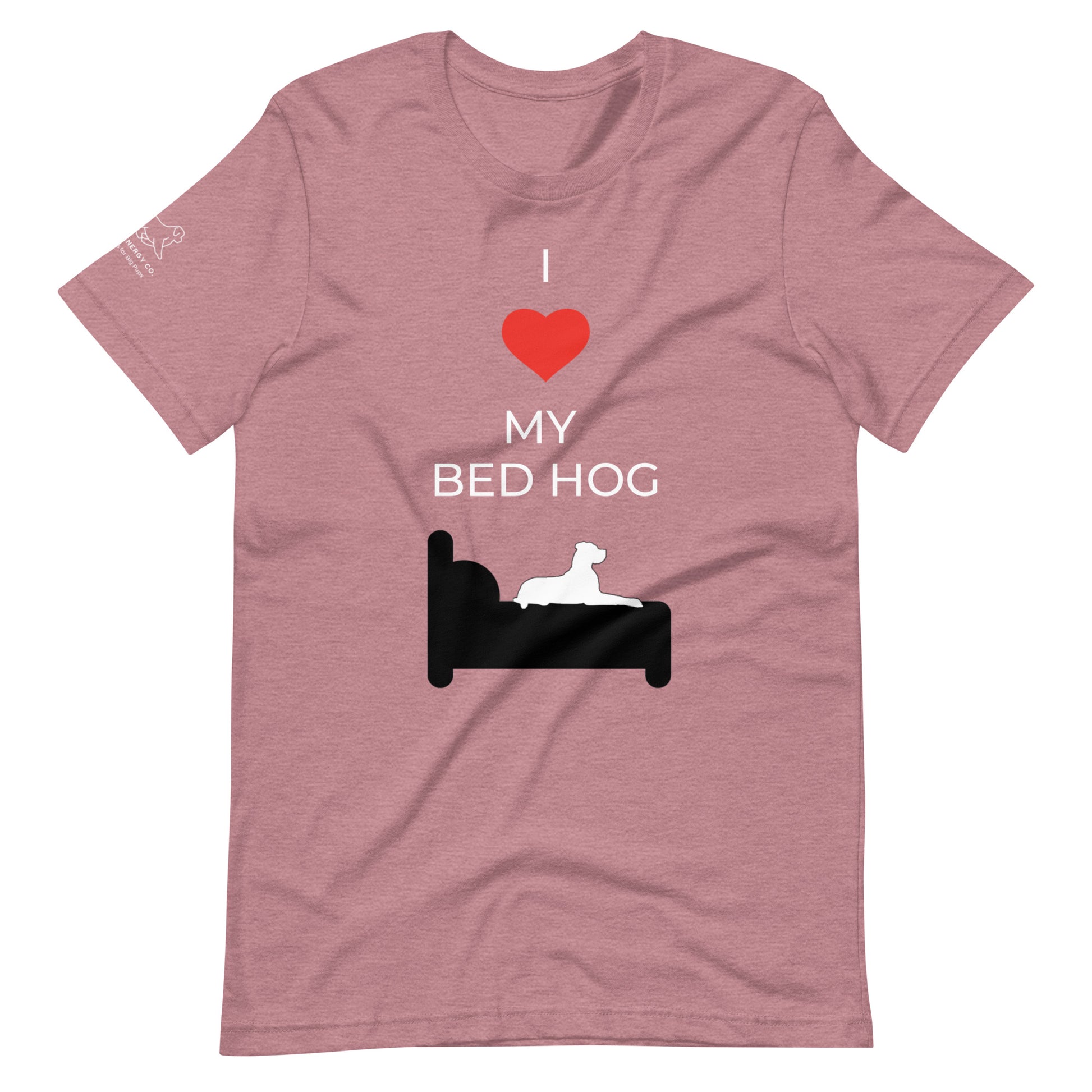 Front of a heather orchid pink t-shirt that reads "I love my bed hog" in white text over an illustration that is the white silhouette of a large dog laying on the dark silhouette of a bed. The word "love" is replaced by a red heart symbol.