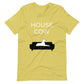 Front of a strobe green/yellow t-shirt that reads "House Cow" in white text over an illustration that is the white silhouette of a large dog laying on the dark silhouette of a couch.