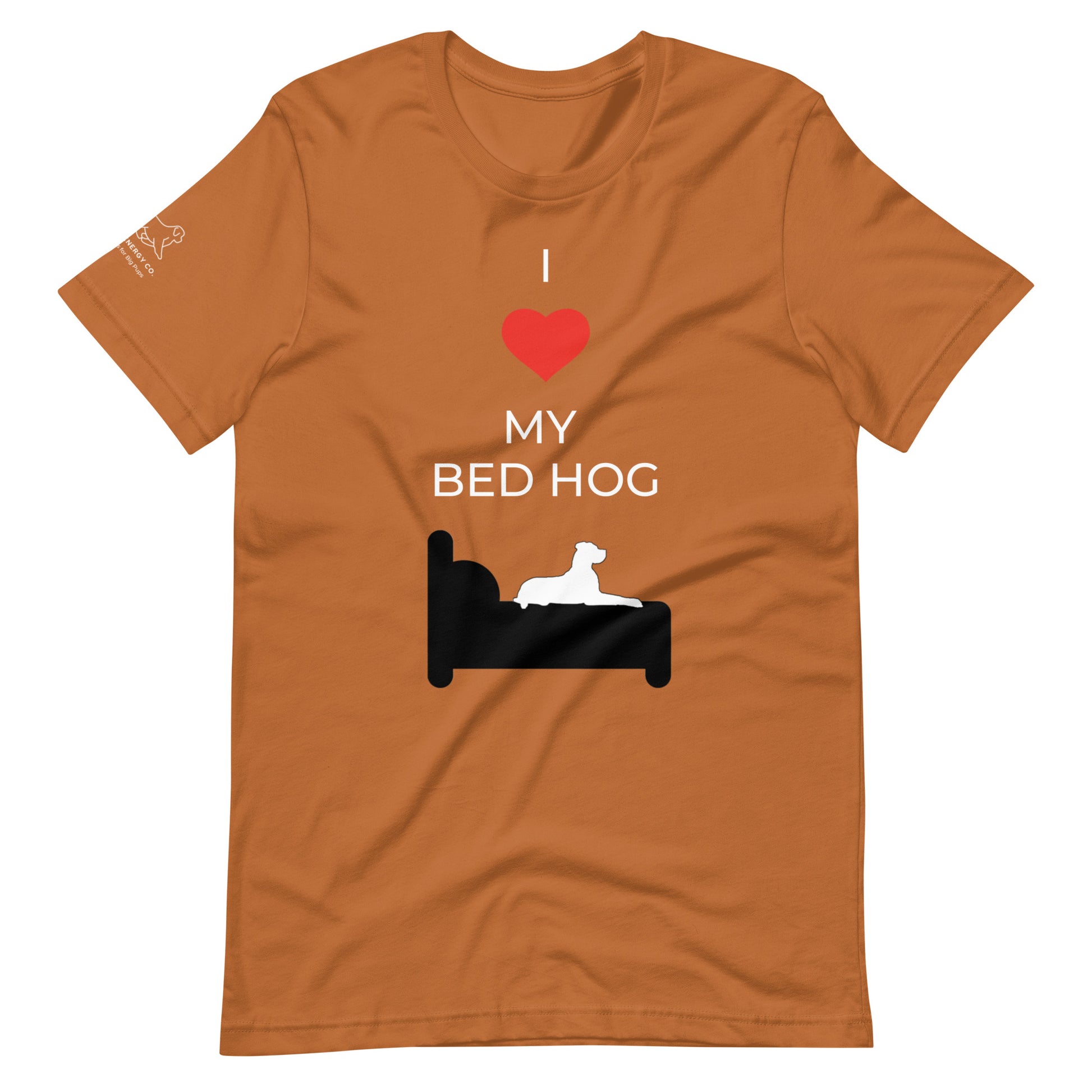 Front of a toast orange t-shirt that reads "I love my bed hog" in white text over an illustration that is the white silhouette of a large dog laying on the dark silhouette of a bed. The word "love" is replaced by a red heart symbol.