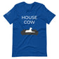 Front of a true royal blue t-shirt that reads "House Cow" in white text over an illustration that is the white silhouette of a large dog laying on the dark silhouette of a couch.